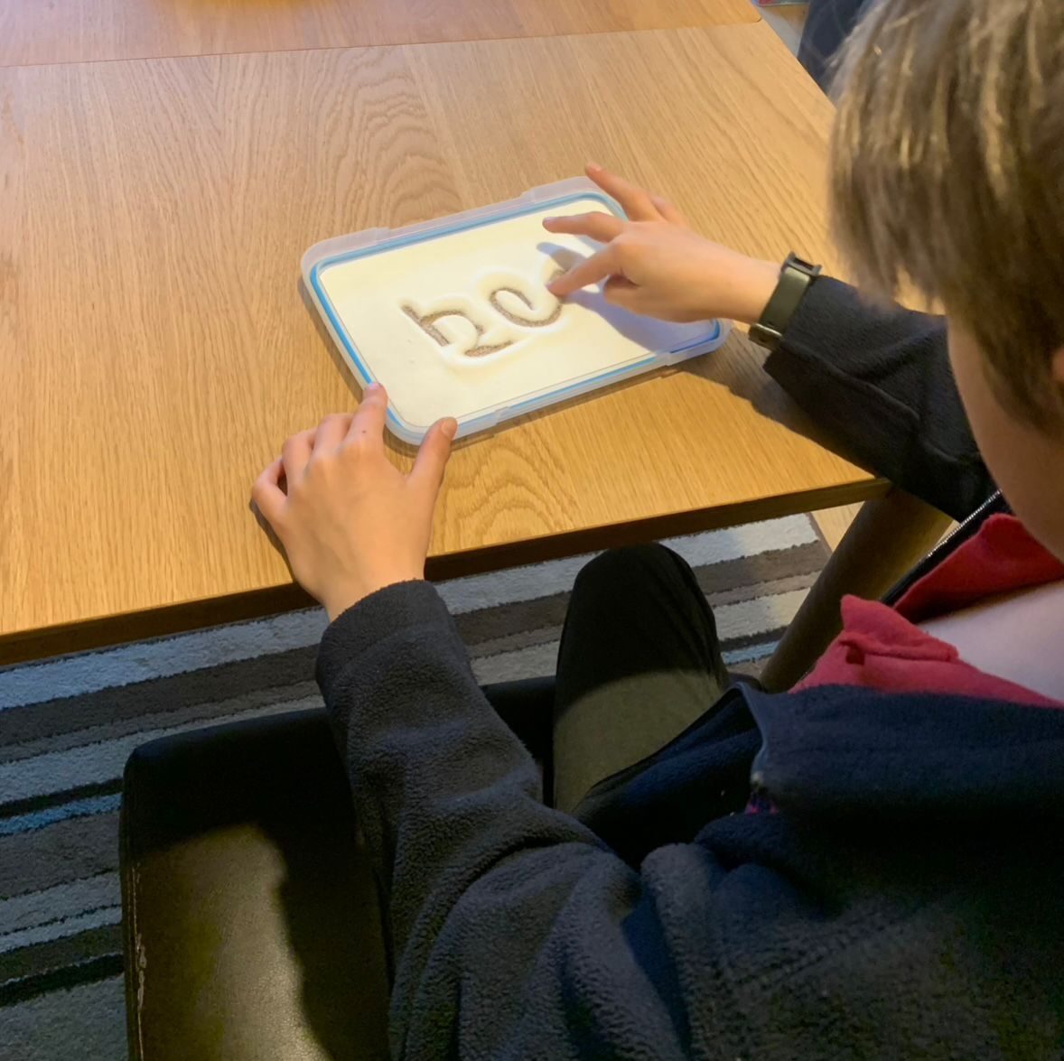 A child’s hands working on a worksheet